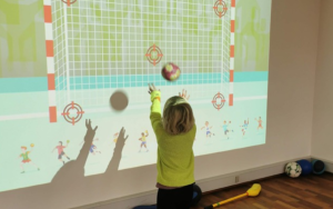 Child playing interactive sports game on ActiveFloor SportsWall projector